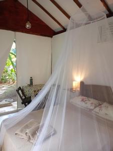 a bed with a mosquito net in a room at Acqua Jungle Lodge, Bangalô na selva in Abraão
