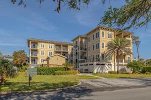 an apartment building with a palm tree in front of it at Sea Gate #103 in Saint Simons Island