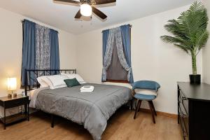 een slaapkamer met een bed, een ventilator en een stoel bij Spacious 3bdr near 6Flags-Naval Base-Casino in Waukegan