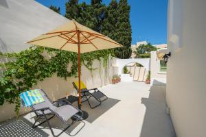 a patio with two chairs and an umbrella at Vintage Charm in Kos Town