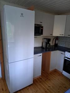 Una cocina con un refrigerador blanco en una habitación. en Aurora cottage, en Oulu