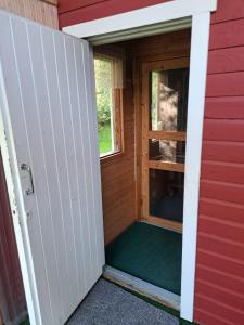 Una puerta a una caseta de perro con una ventana en Aurora cottage, en Oulu