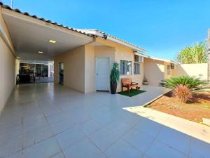 a house with a large concrete patio in front of it at Casa 2 Suítes + 2 quartos piscina e churrasqueira in Foz do Iguaçu