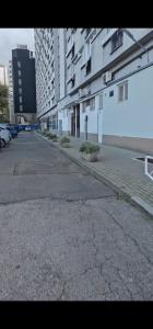 une rue vide dans une ville avec de grands immeubles dans l'établissement Oddzielny pokój we wspólnym mieszkaniu, à Varsovie