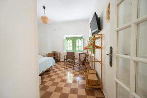 a room with a bed and a television and a door at Vintage Charm in Kos Town
