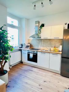 a kitchen with white cabinets and a stove top oven at CASA CLARA Walk-in Shower in Magdeburg +23 photos