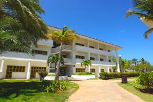 a large white building with palm trees in the foreground at Sunsol Ecoland in Pedro Gonzalez