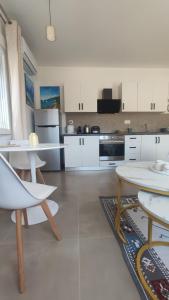 a kitchen with white cabinets and a table and chairs at Julia's Home in Patitiri