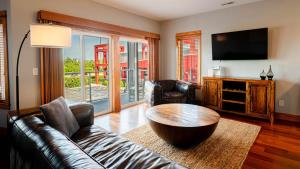 a living room with a leather couch and a table at The Boiler - 3-Bedroom, 3-Bathroom Penthouse Suite at REAL Watersports in Waves