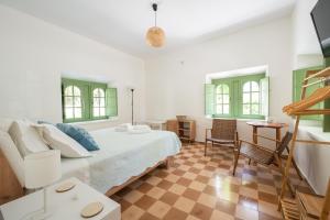 a bedroom with a bed and a couch and windows at Vintage Charm in Kos Town +56 photos