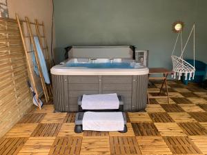 a bathroom with a tub with towels on the floor at Maison détente avec jacuzzi spa massant in Nogent-sur-Vernisson