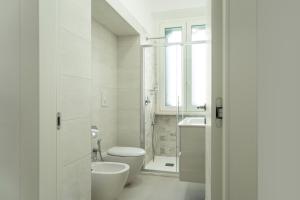 a white bathroom with a toilet and a sink at Casa Vacanze Vanda in Ostuni +19 photos