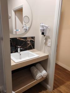 une salle de bain avec un lavabo et un miroir dans l'établissement Sea view, à Étretat 25 autres photos