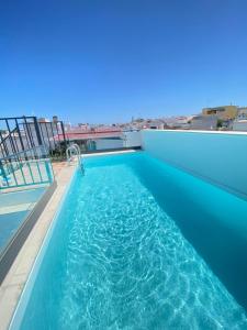 a swimming pool on the roof of a building at Mar-Ria 4 in Fuzeta