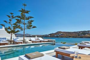 a villa with a swimming pool and a resort at Mykonos Waves Beach House & Suites in Ornos