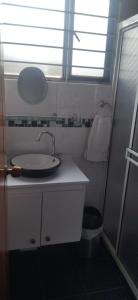 a white bathroom with a sink and a window at Cabaña La Veranera in Paipa