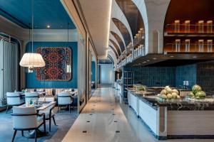 ein Restaurant mit blauen Wänden, Tischen und Stühlen in der Unterkunft InterContinental Hotels Yining by IHG in Yining