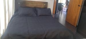 a large bed in a bedroom with a wooden headboard at Cabaña La Veranera in Paipa +13 photos