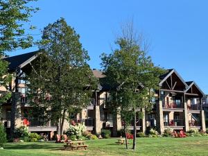 a large building with picnic tables in front of it at Condo 2 chambres avec accès aux pistes de ski in Saint-Sauveur-des-Monts +24 photos