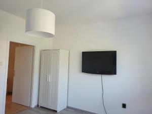 a flat screen tv hanging on a white wall at Vitorlásház in Balatonvilágos