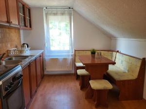 a kitchen with a table and a sink and a window at Vitorlásház in Balatonvilágos