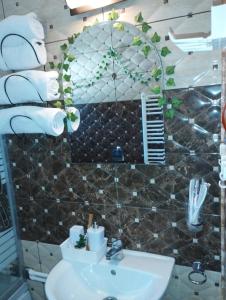 a bathroom with a sink and a mirror and towels at Cabana Dănuțza in Arieşeni +76 photos