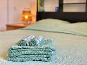 a pile of folded towels on a bed at " Balcon Nature " Terrasse - TV - Fibre in Muret +13 photos