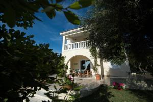 uma vista para uma casa branca com um quintal em Villa Feia em Katakolo
