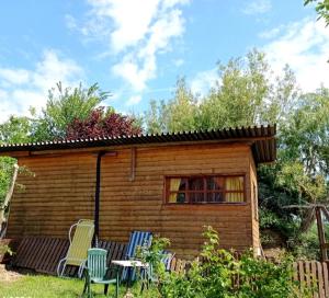a small wooden cabin with chairs and a table at A-Sissy-Hof Tierschutzhof in Unterweg