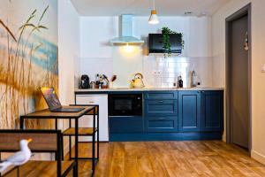 a kitchen with blue cabinets and a bird sitting on a table at Le Nid du Marin in Lorient +17 photos