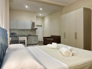 a large bedroom with two beds and a kitchen at Helios Home in Reggio di Calabria