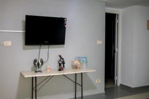 a room with a table with a television on a wall at Maisonabdou in Sousse
