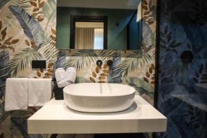 a bathroom with a white sink on a counter at LUNA Gallery Suites in Naples +77 photos