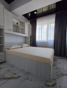 una camera da letto con un letto grande con una finestra di Cazare la mare Stefan a Mamaia Nord - Năvodari