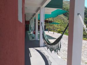 a hammock hanging outside of a building with a house at Eco Pousada São Francisco PETAR in Iporanga +20 photos