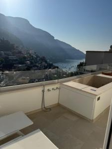 a white bathroom with a view of a mountain at Hotel Posa Posa in Positano