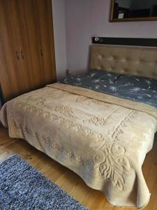 a bed in a bedroom with a brown blanket on it at MM Apartments in Žabljak