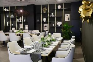 a dining room with a long table and white chairs at Hotel Puerto Palace in Puerto de la Cruz