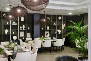 a dining room with a table and white chairs at Hotel Puerto Palace in Puerto de la Cruz