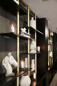 a shelf with a white horse statue and candles at Hotel Puerto Palace in Puerto de la Cruz