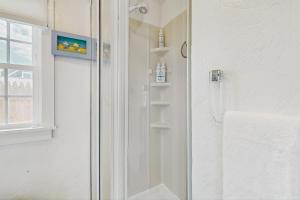 a shower with a glass door in a bathroom at The Jib & The Genoa in Dennis Port +24 photos
