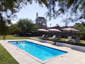 a swimming pool with chairs and a person in it at The Hills Guest House in Newcastle