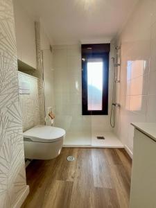 a white bathroom with a tub and a toilet at Casa Yayi in Luanco +56 photos