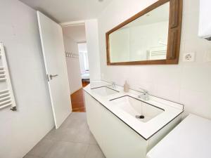 a white bathroom with a sink and a mirror at Apartamento Plaza España in Madrid