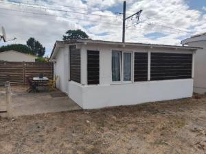 mały biały dom ze stołem na dziedzińcu w obiekcie mini maison mini budget w mieście Soulac-sur-Mer