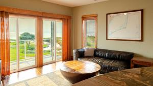 a living room with a leather couch and a table at The Planet - Waterfront 3-Bedroom, 3-Bathroom Penthouse Suite at REAL Watersports in Waves