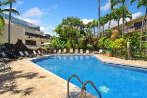 a swimming pool in a resort with palm trees at Prince Kuhio 115 in Kipu