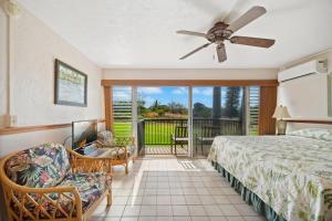 a bedroom with a bed and a ceiling fan at Prince Kuhio 115 in Kipu +17 photos