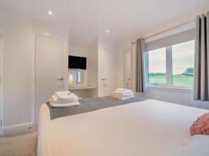 Un dormitorio blanco con una cama grande y una ventana. en 1 Bed in Langbank 73846, en Langbank