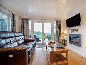 Una sala de estar con un sofá de cuero y un televisor. en 1 Bed in Langbank 73846, en Langbank